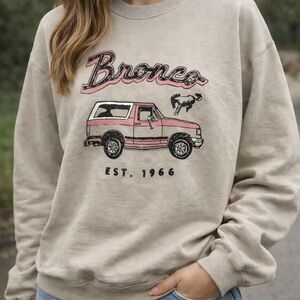 Junk Food Clothing Beige Crewneck Sweatshirt with Pink Bronco Graphic